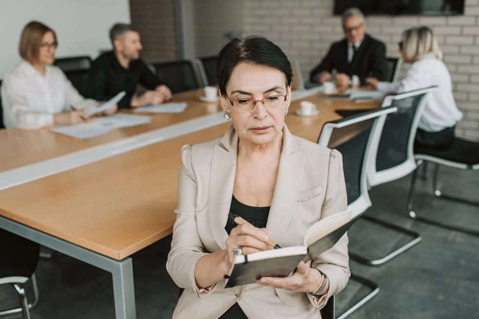 Persona che scrive su un quaderno durante una sessione di brainstorming strategico